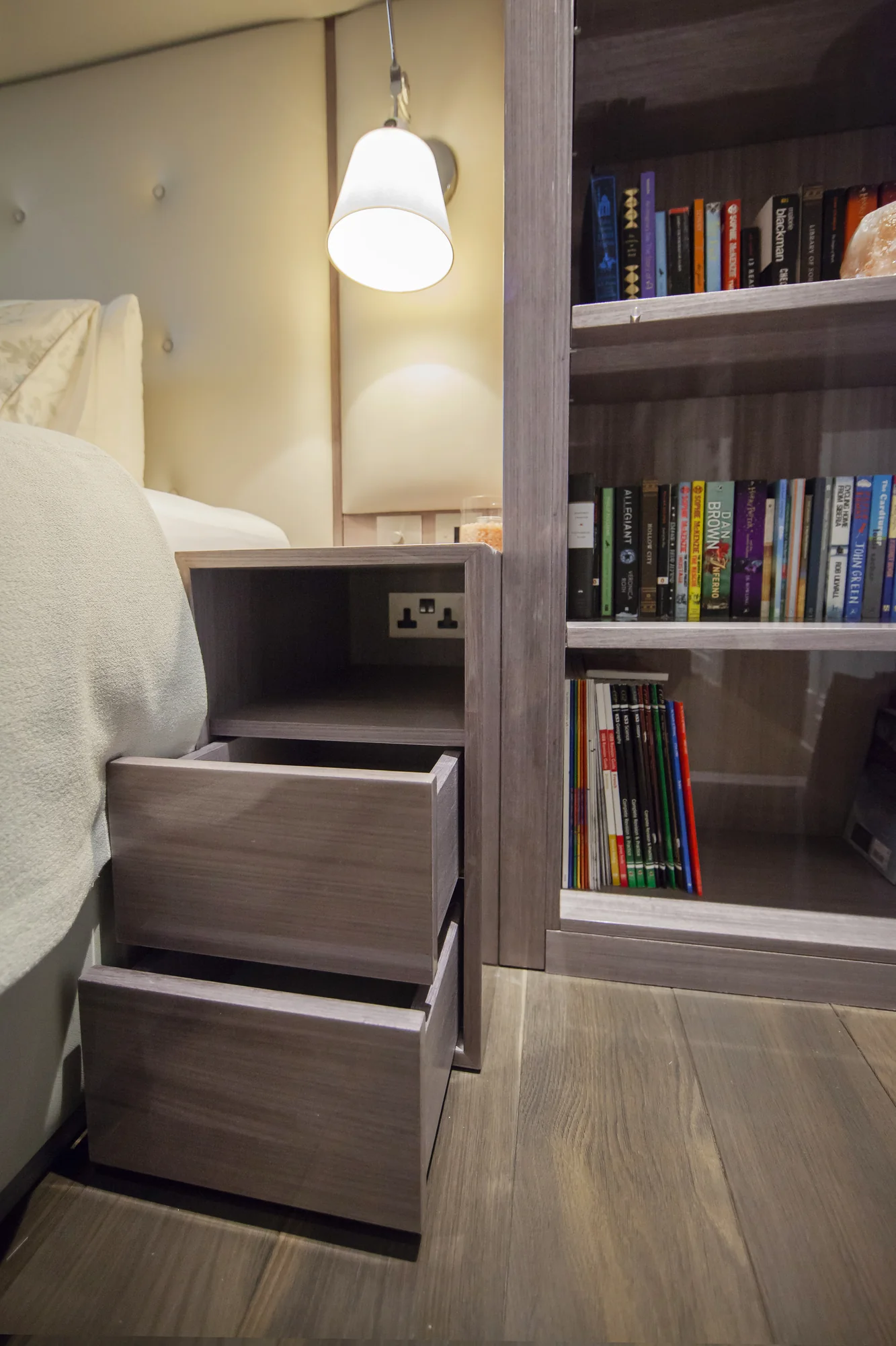 Open bedside drawers beneath the fitted bedroom bookcase
