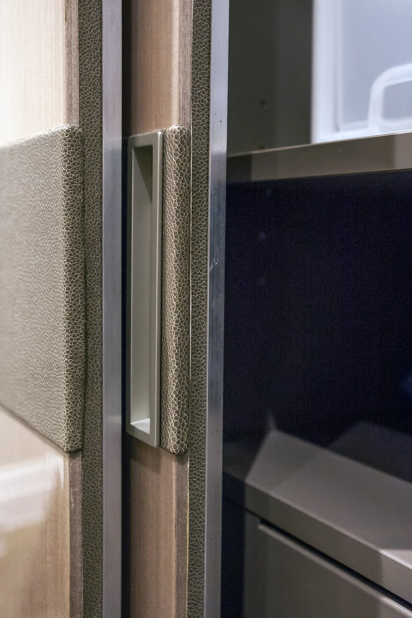 Close detail of a textured wardrobe edge and recessed fitting in the bedroom