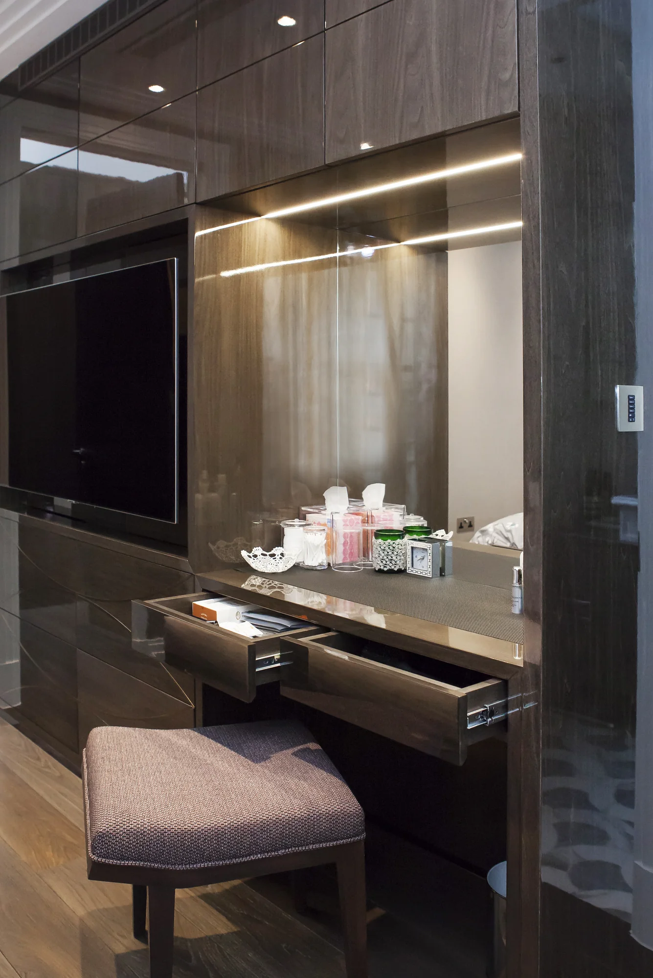Fitted dressing table with an open drawer beside the television