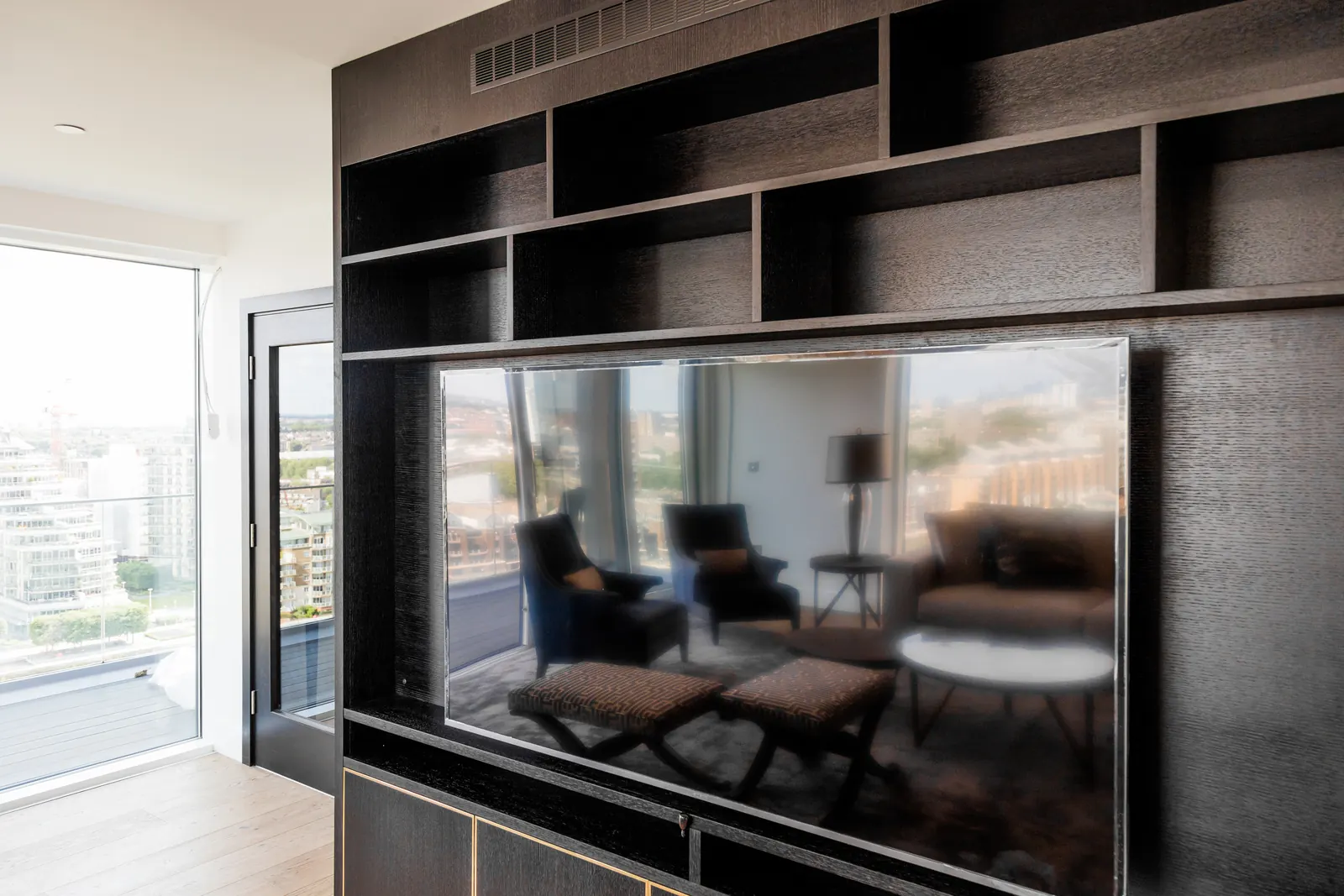 Angled detail of dark oak-grain shelving and fitted media cabinetry