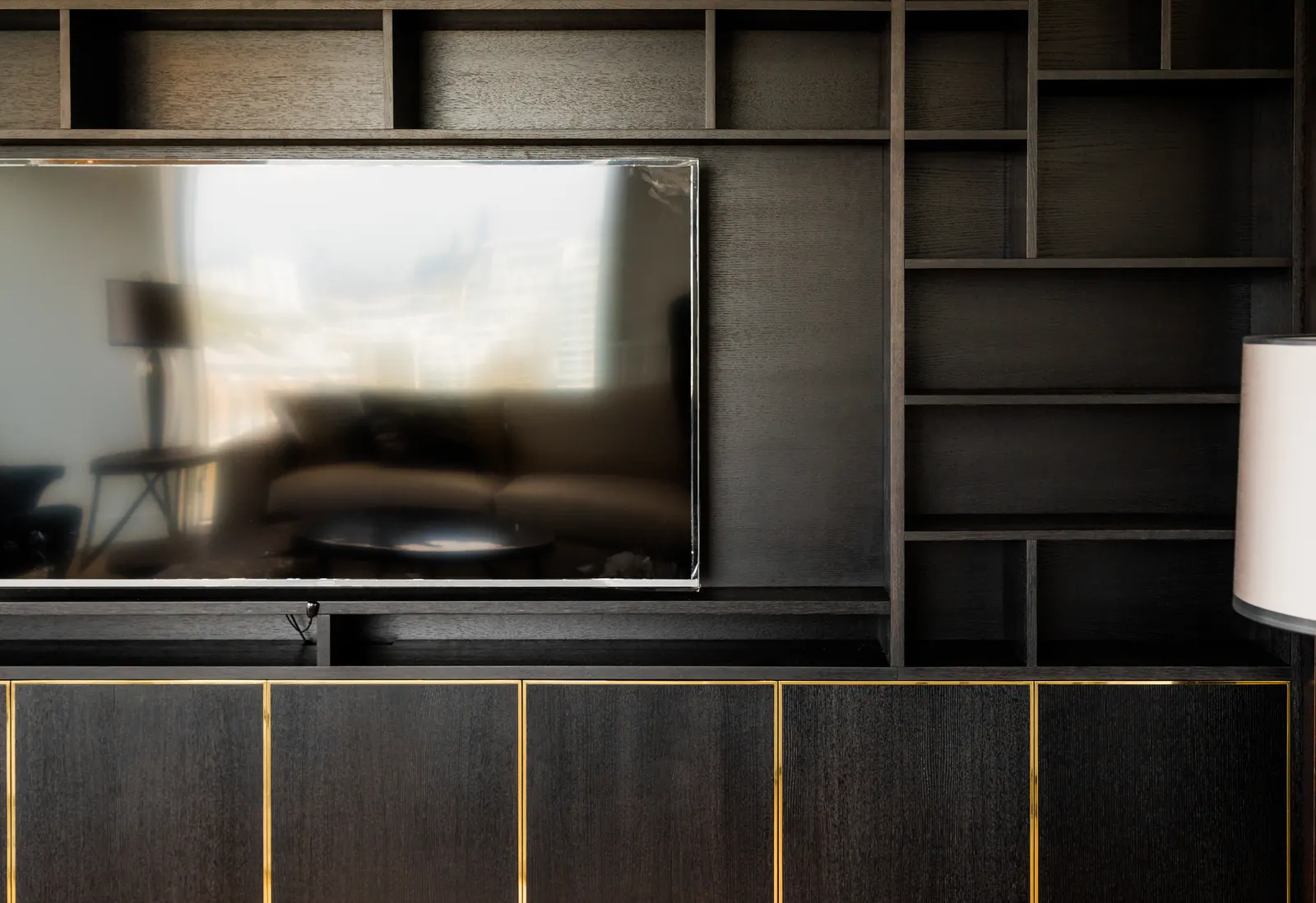 Integrated television recess and shelving detail in black oak media wall