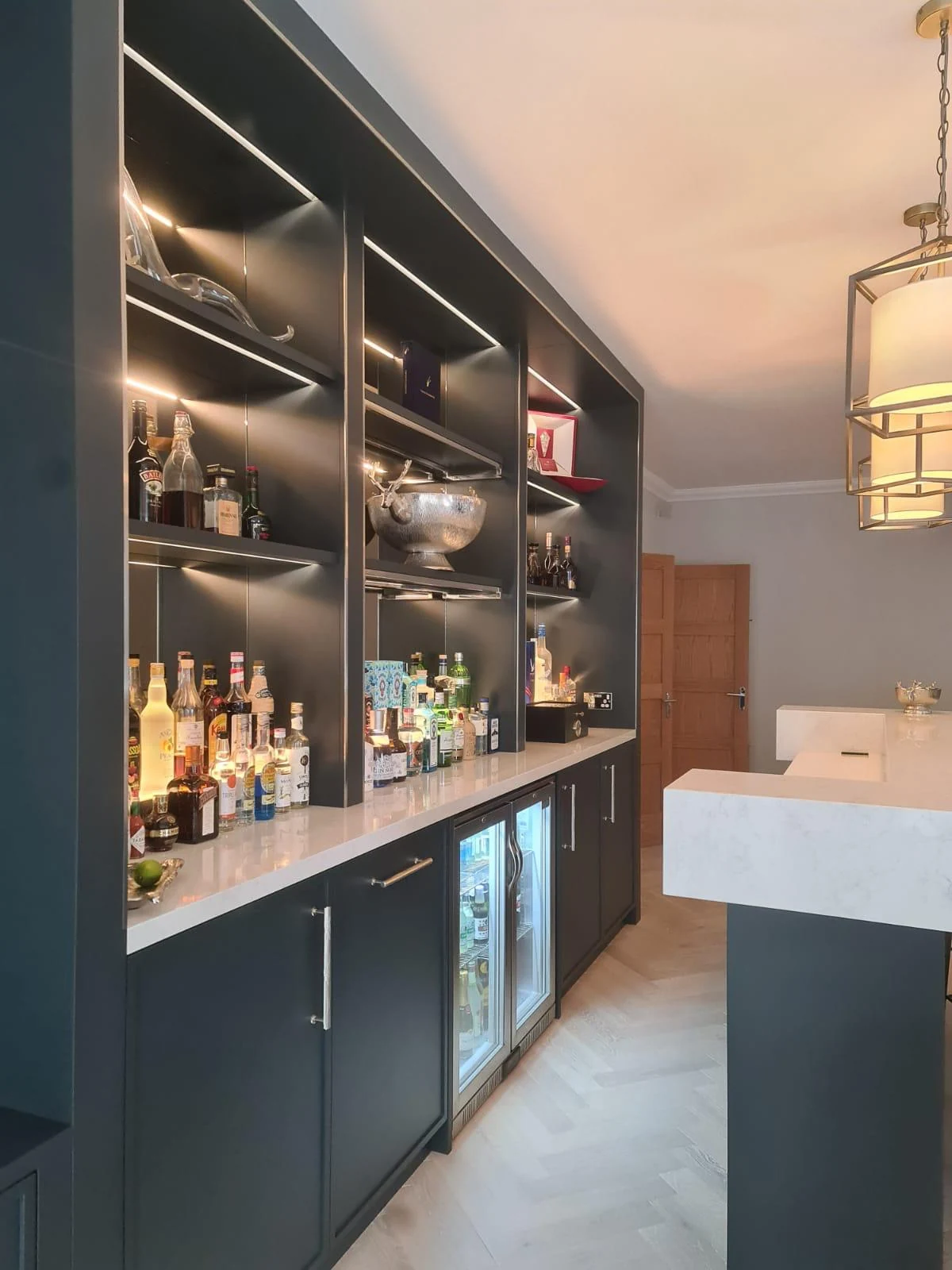 Close view of the back-bar cabinetry, drinks display and glazed under-counter refrigerators.
