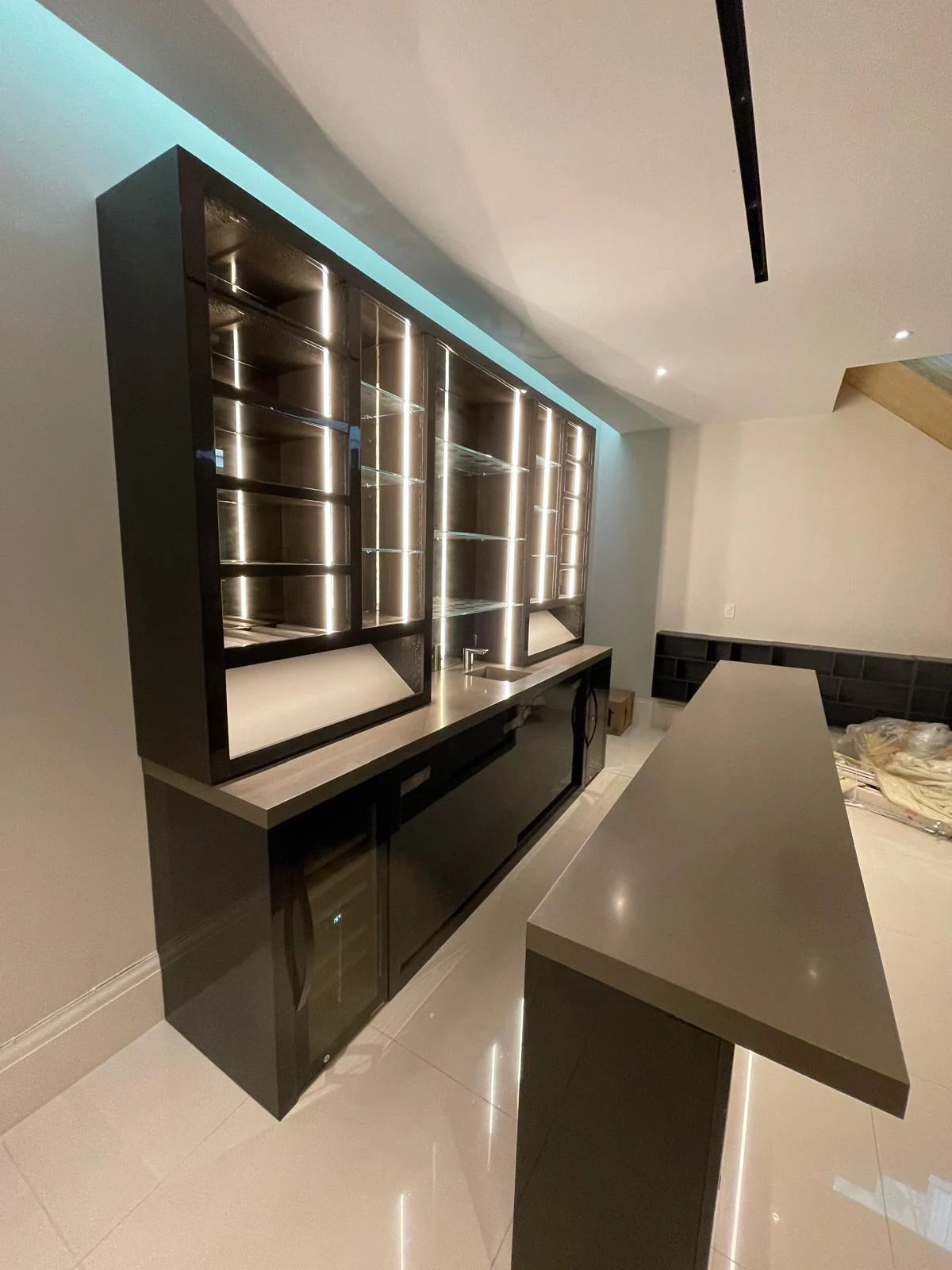 Side view along the mirrored back-bar shelving and storage cupboards.