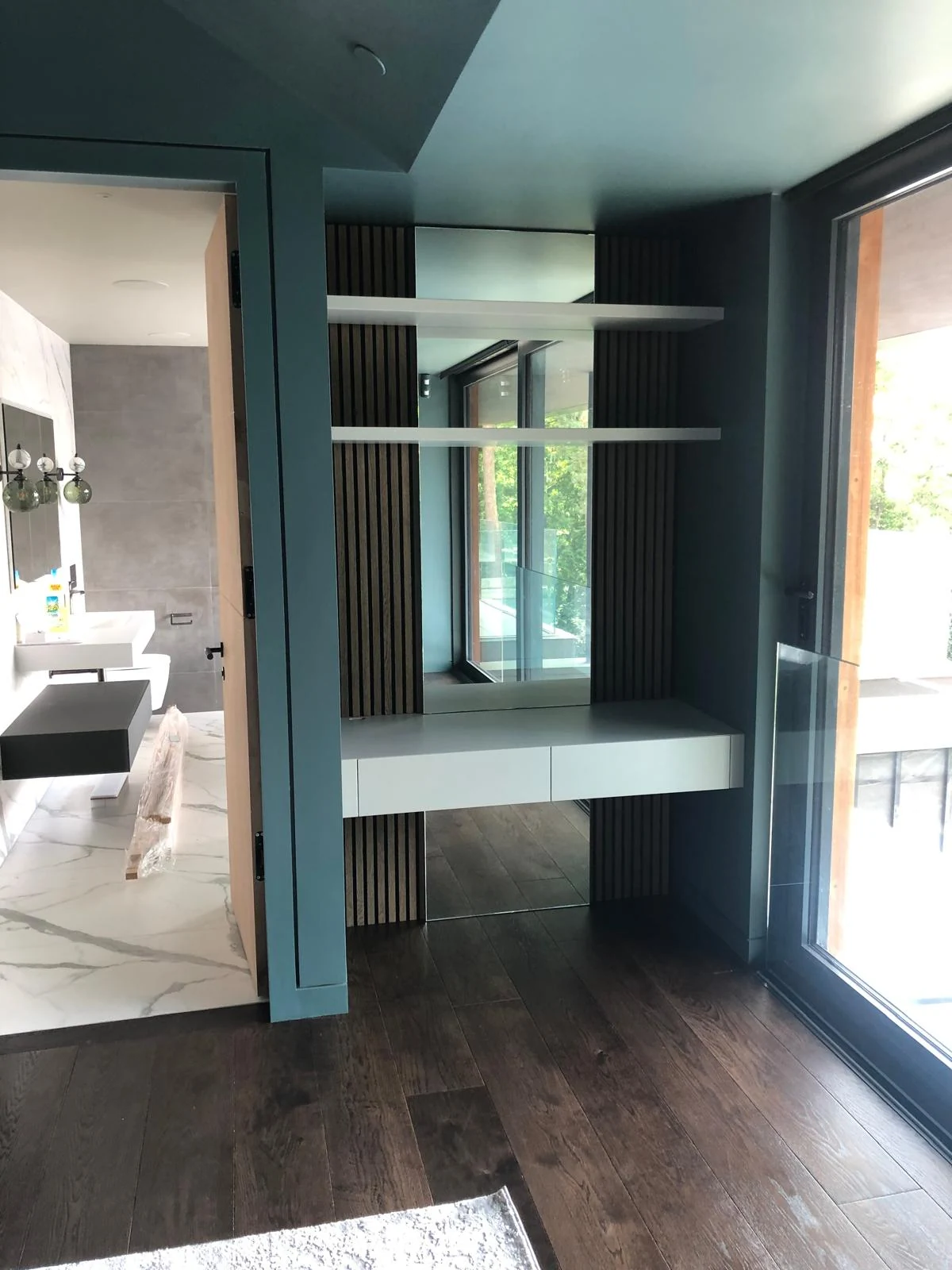 Fitted dressing recess with a mirror, slim shelves and a floating surface.