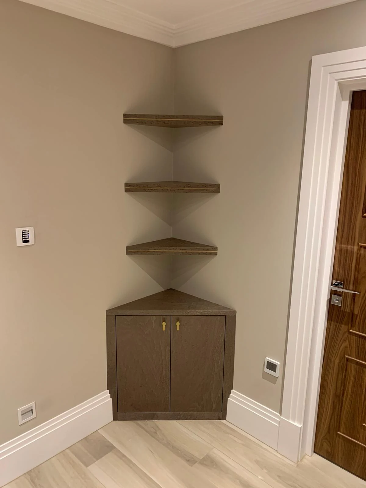 Corner cupboard with three matching floating shelves above.