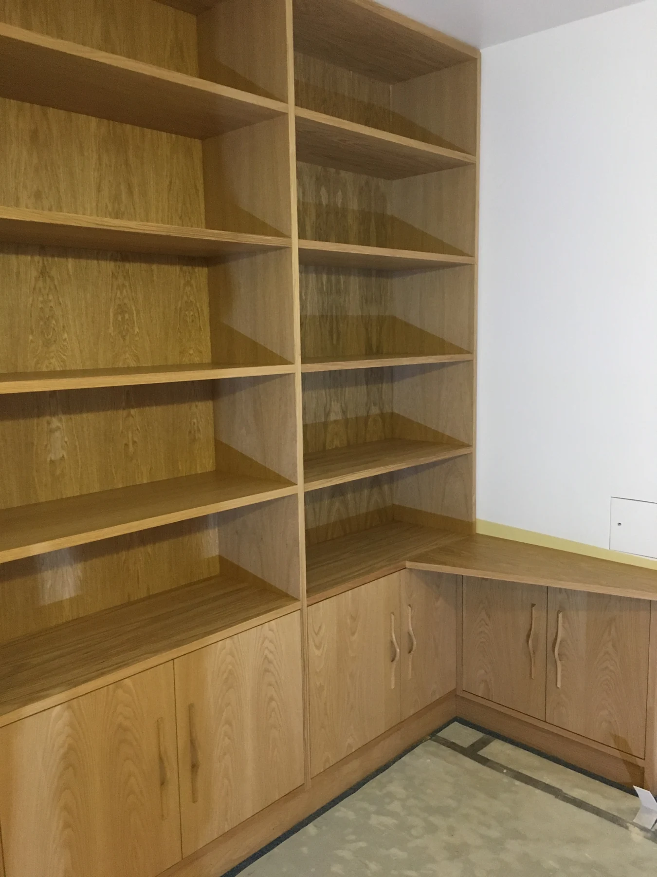 Closer view of the corner library shelving and continuous lower storage.