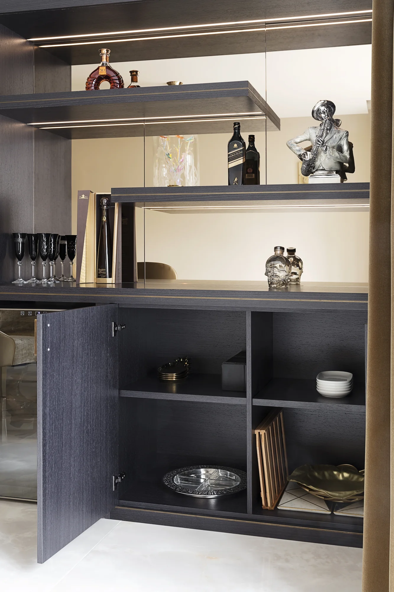 Open lower cupboard beneath mirrored display shelves