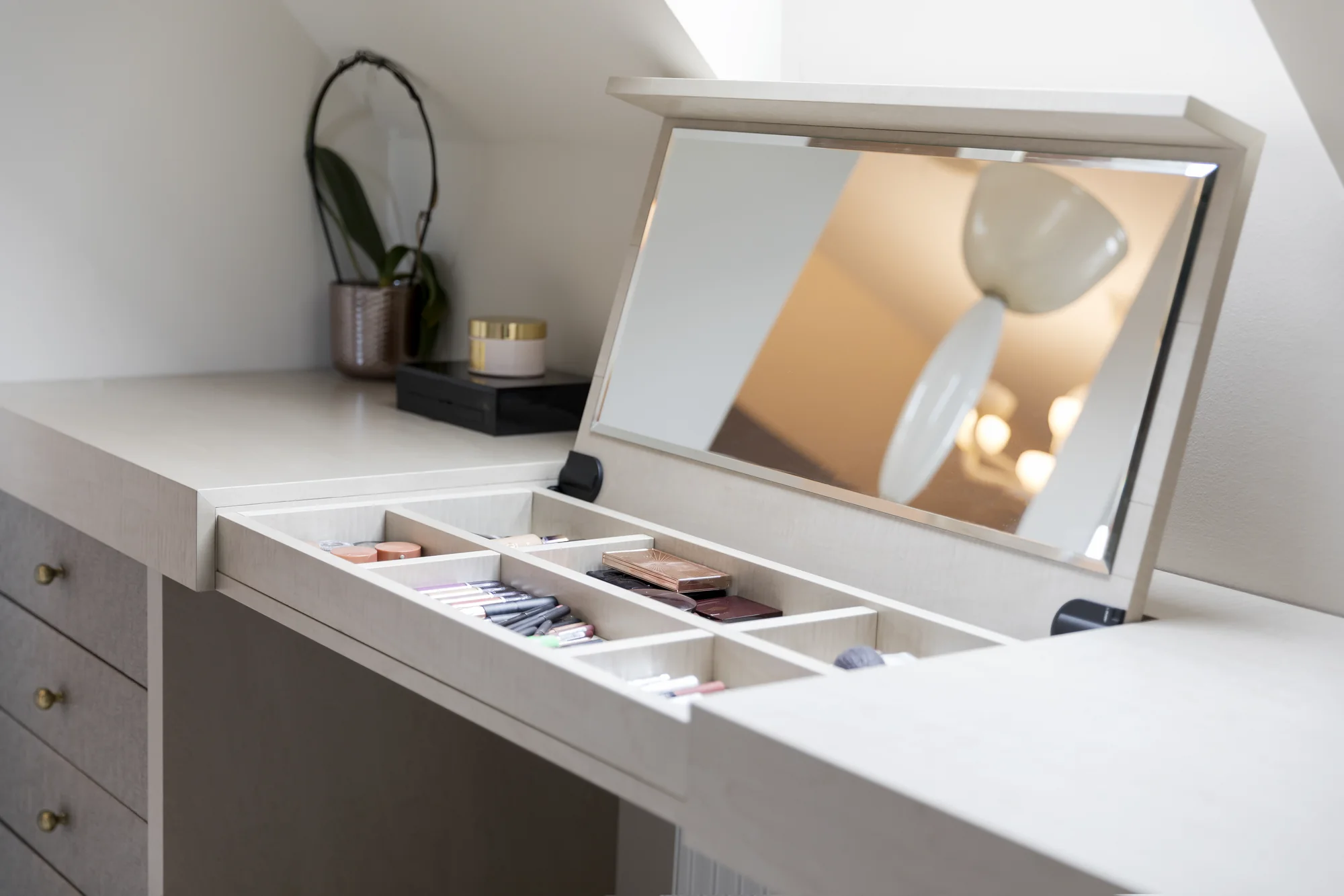 Raised dressing-table mirror above divided cosmetics compartments