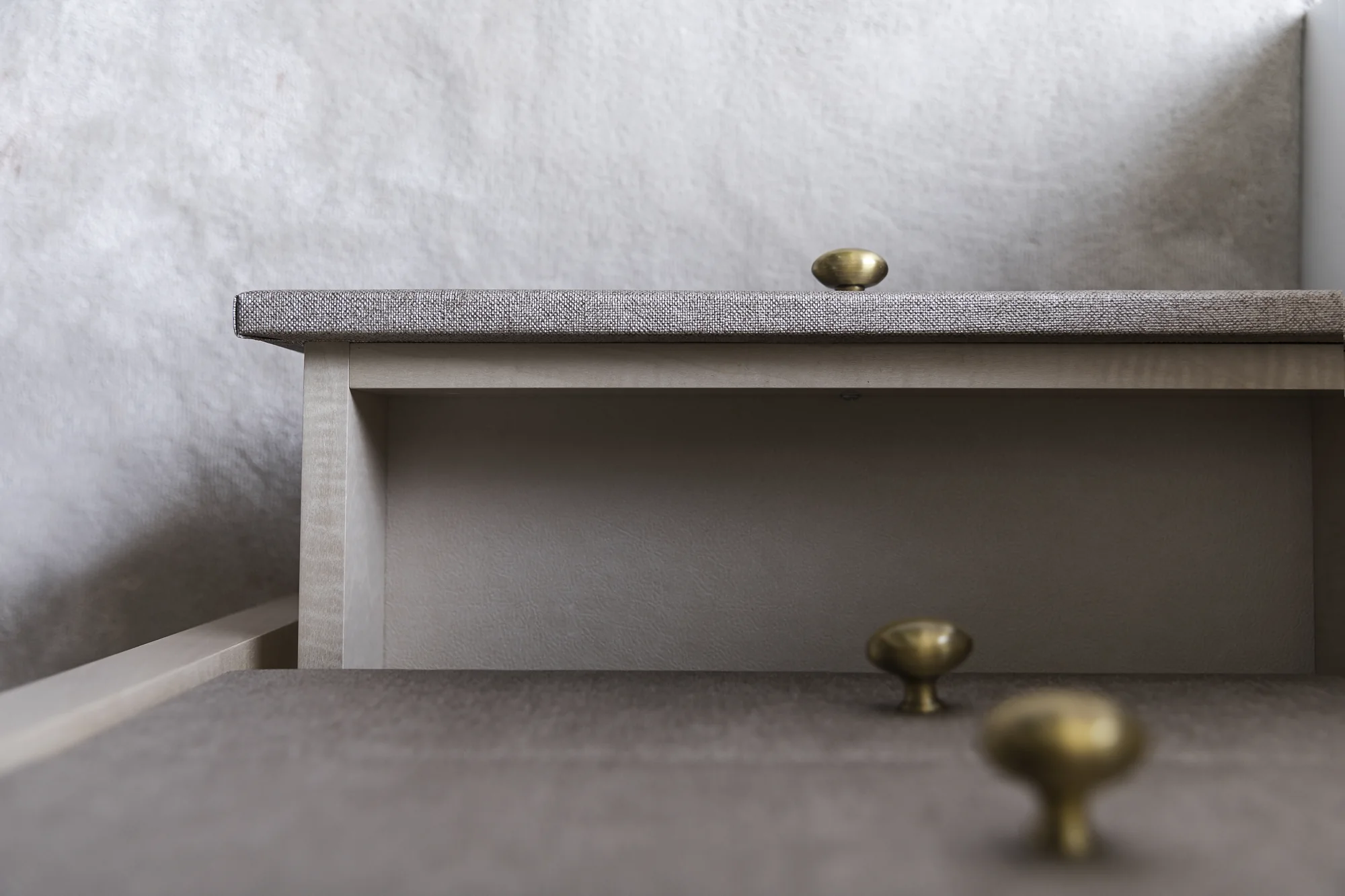Open dressing-table drawer beneath a textured drawer front