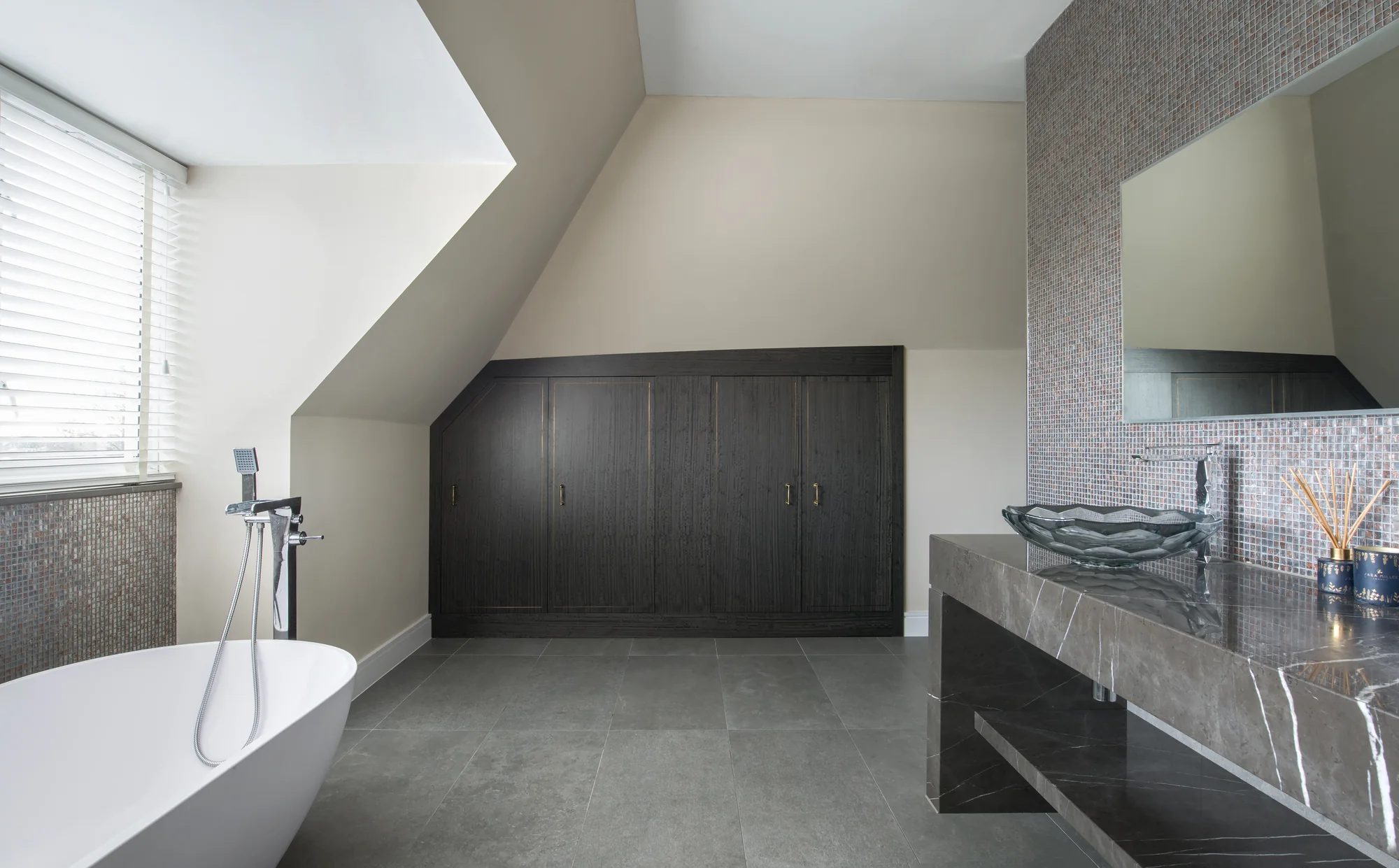 Wide bathroom view of the fitted cupboards beside the bath and vanity