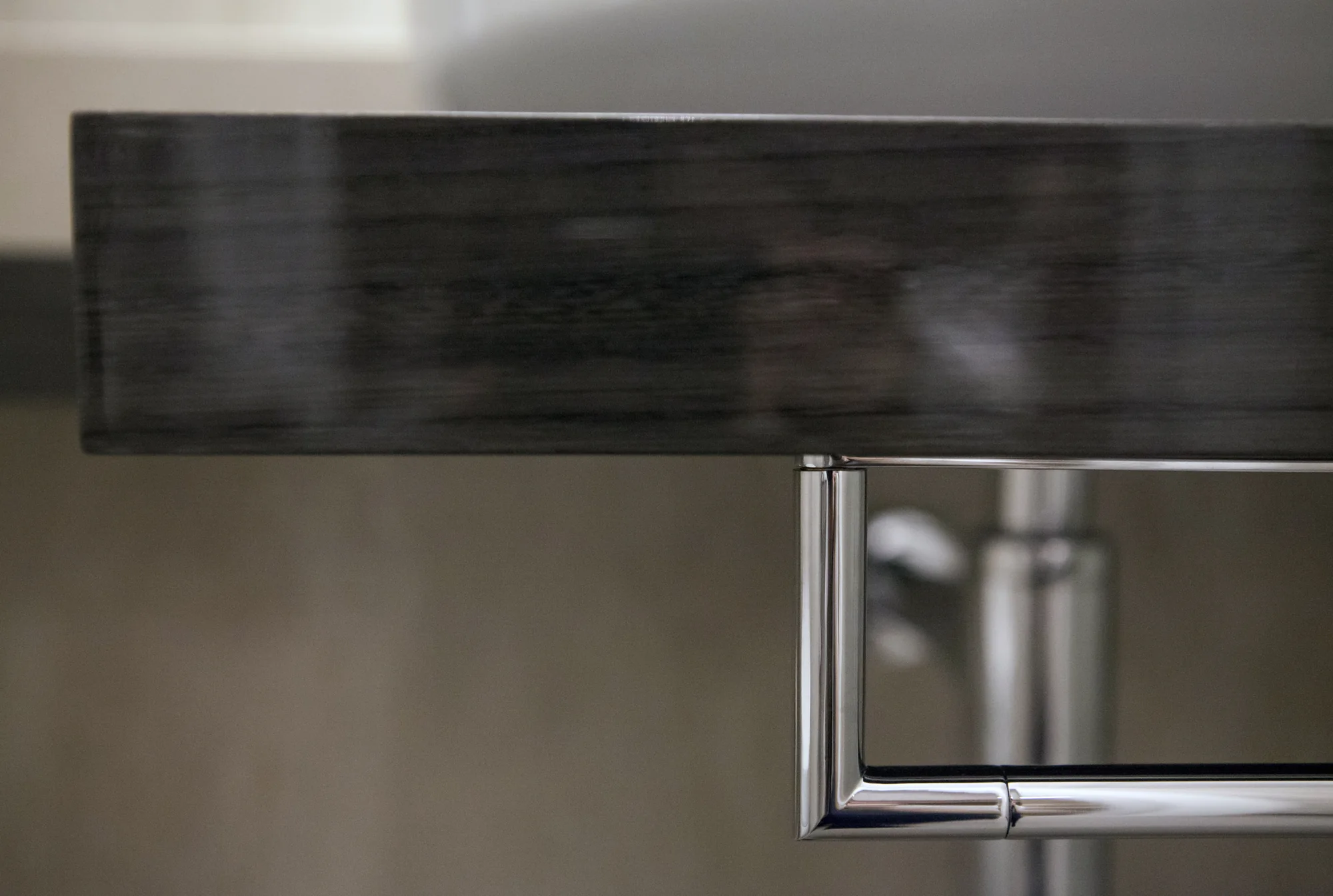 Close-up of the dark desk edge and reflective drawer detail