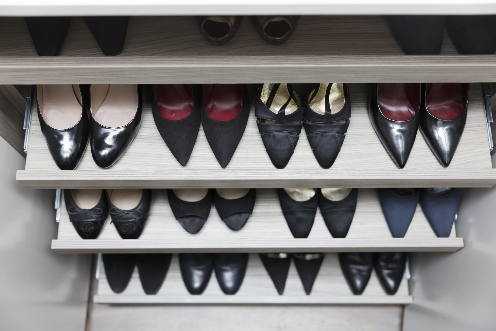 Pull-out shoe shelves inside the fitted cupboard