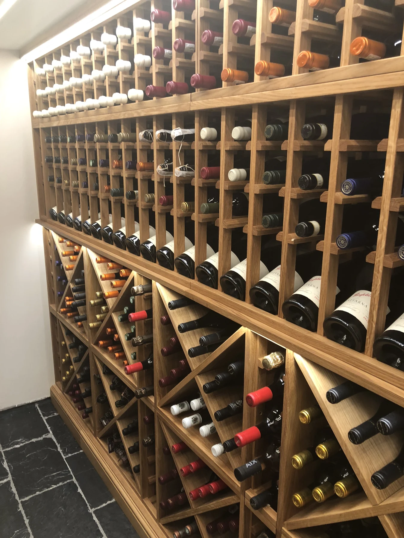 Timber wine rack with individual cubbies and angled bottle compartments.