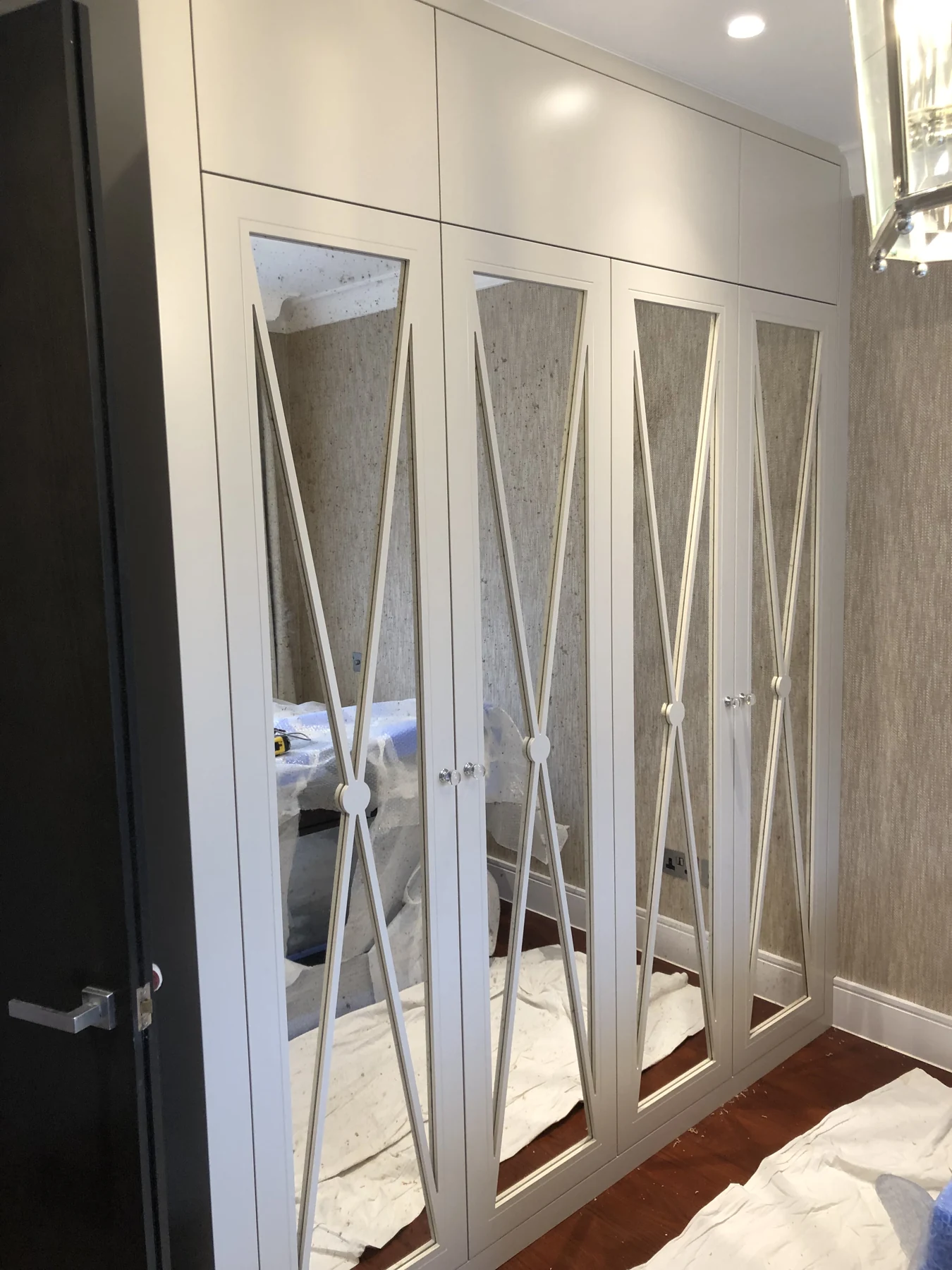 Mirrored wardrobe doors overlaid with elongated geometric detailing.