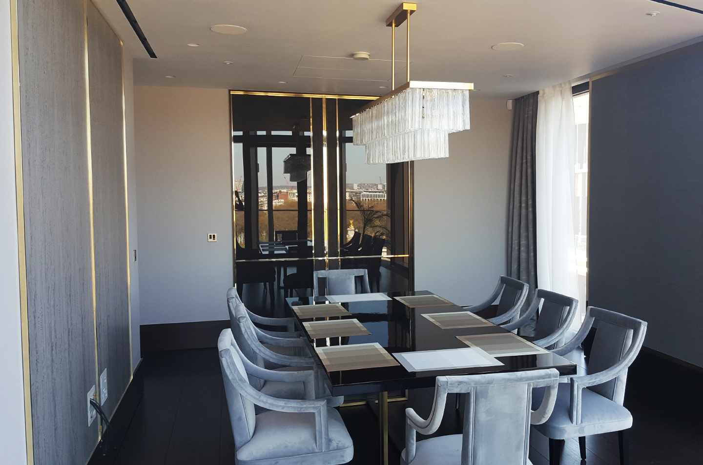 Wide room view of dark reflective panels and integrated doors with brass detailing
