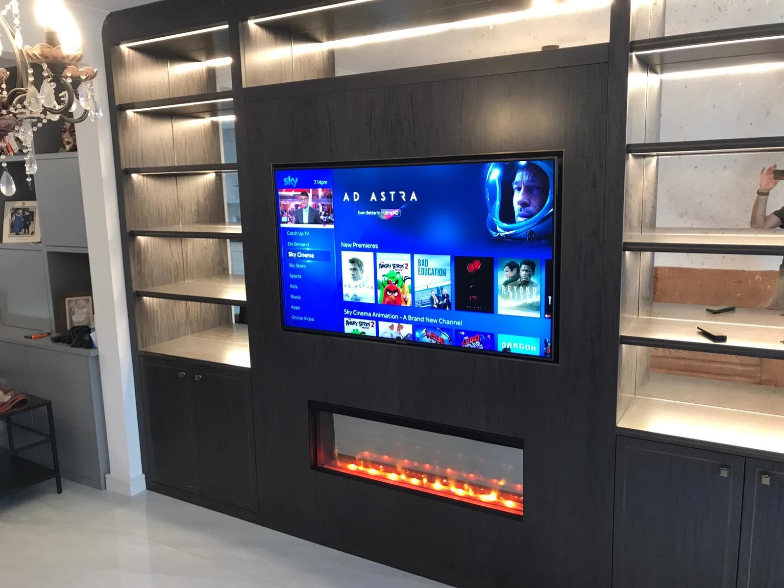 Charcoal media wall with the inset electric fireplace illuminated.