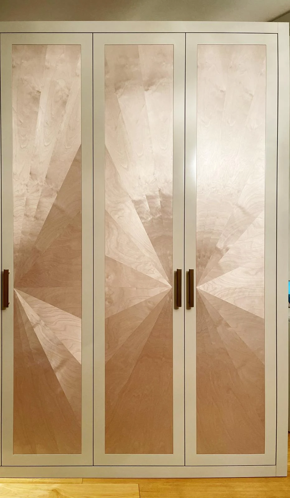 Front view of the pale sunburst-panel wardrobe.