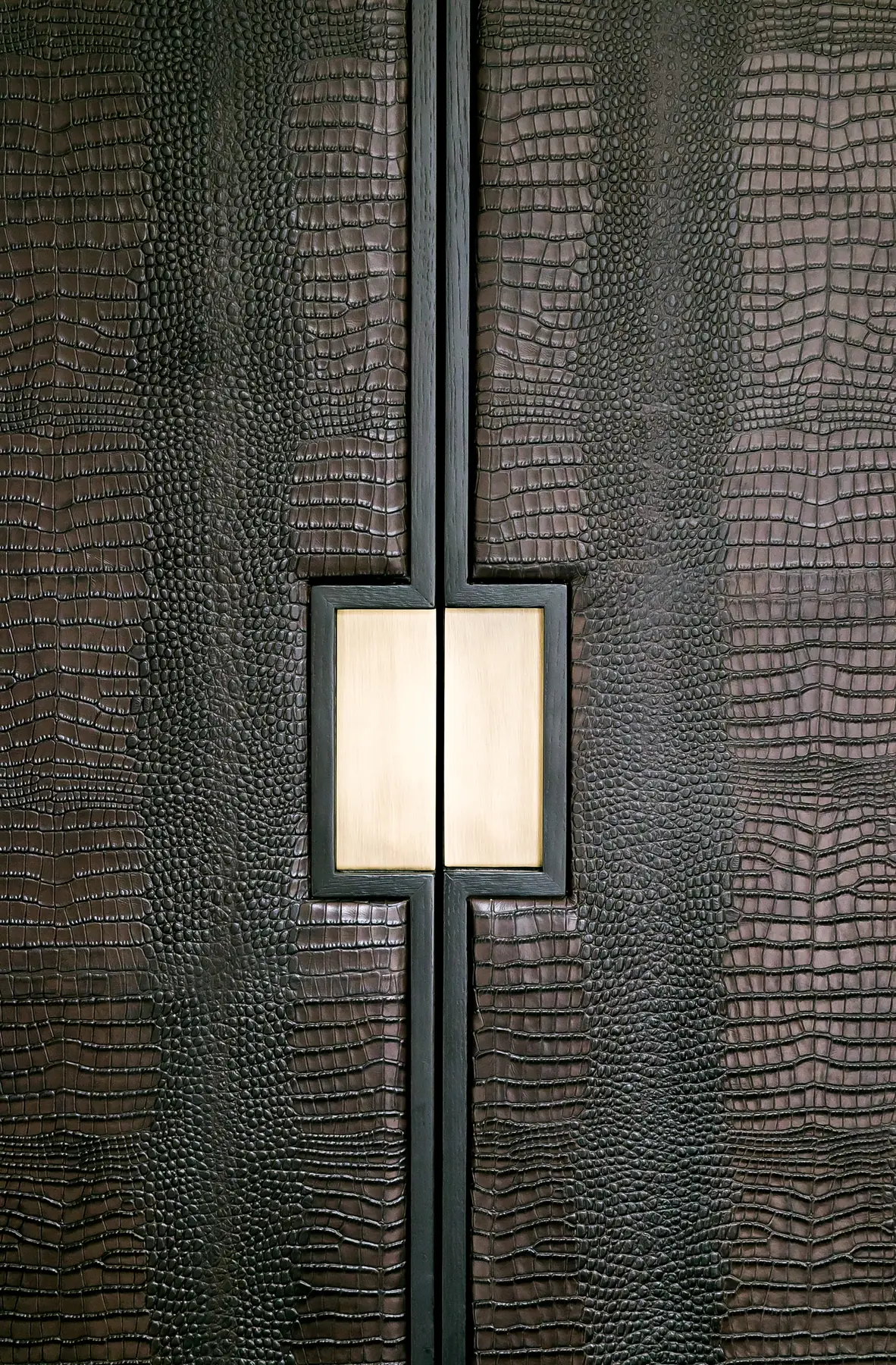 Brass-toned square handle detail on textured cabinet doors