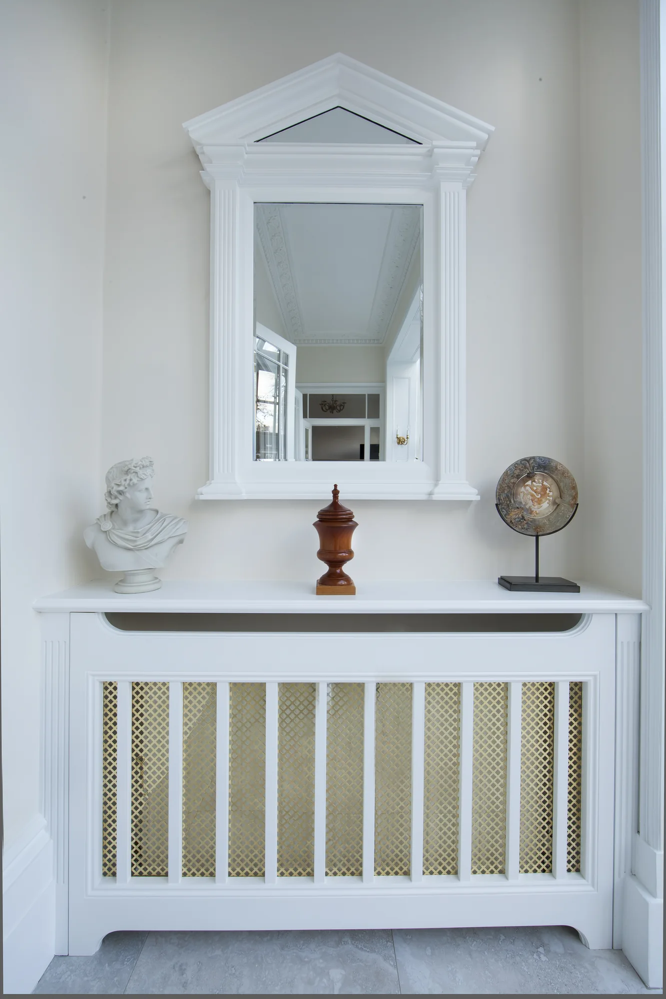 Full front view of a white radiator cover beneath a decorative mirror