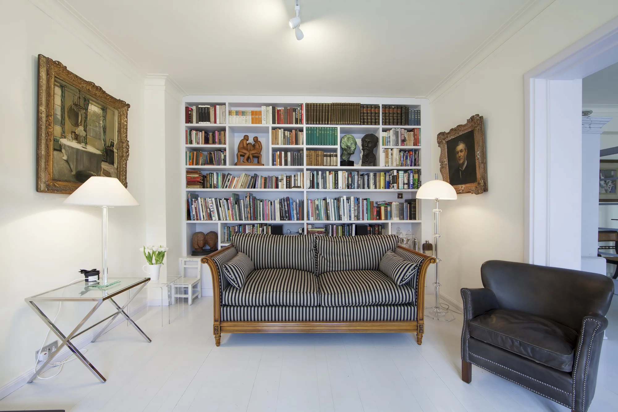 Wider sitting-room view showing the fitted white library wall