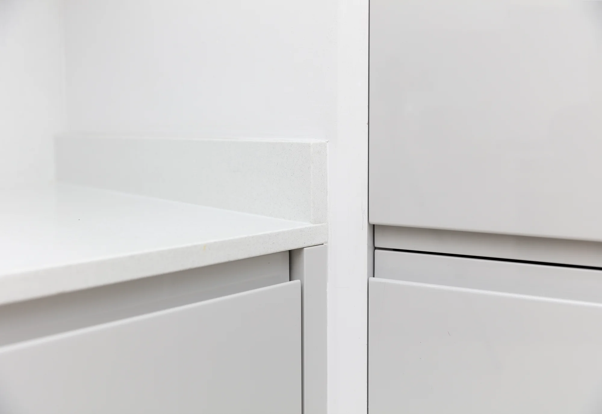 Junction between the worktop, base cabinetry and tall unit