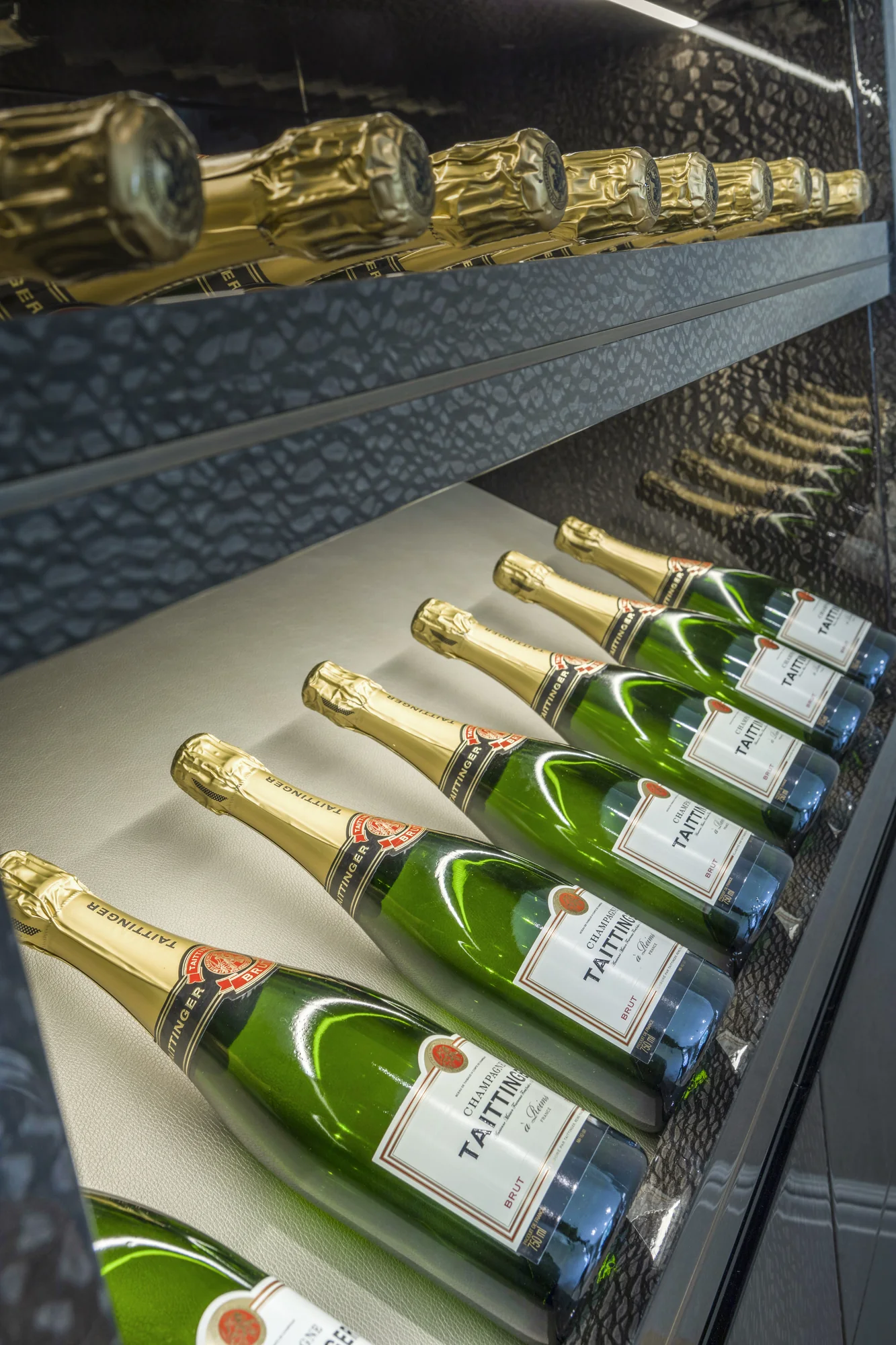Angled bottle display shelves with illuminated dark patterned edges